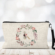 Cosmetic bag with a strap and printed with a rose wreath and initial.