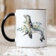 Ceramic mug with black rim and handle featuring a seal and flowers.